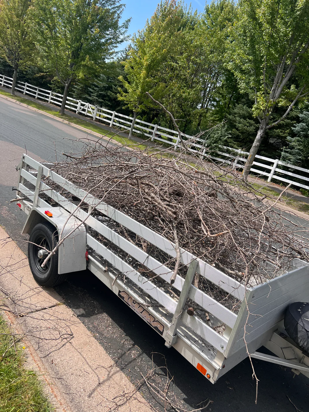Trailer loaded with pruned branches and landscaping debris