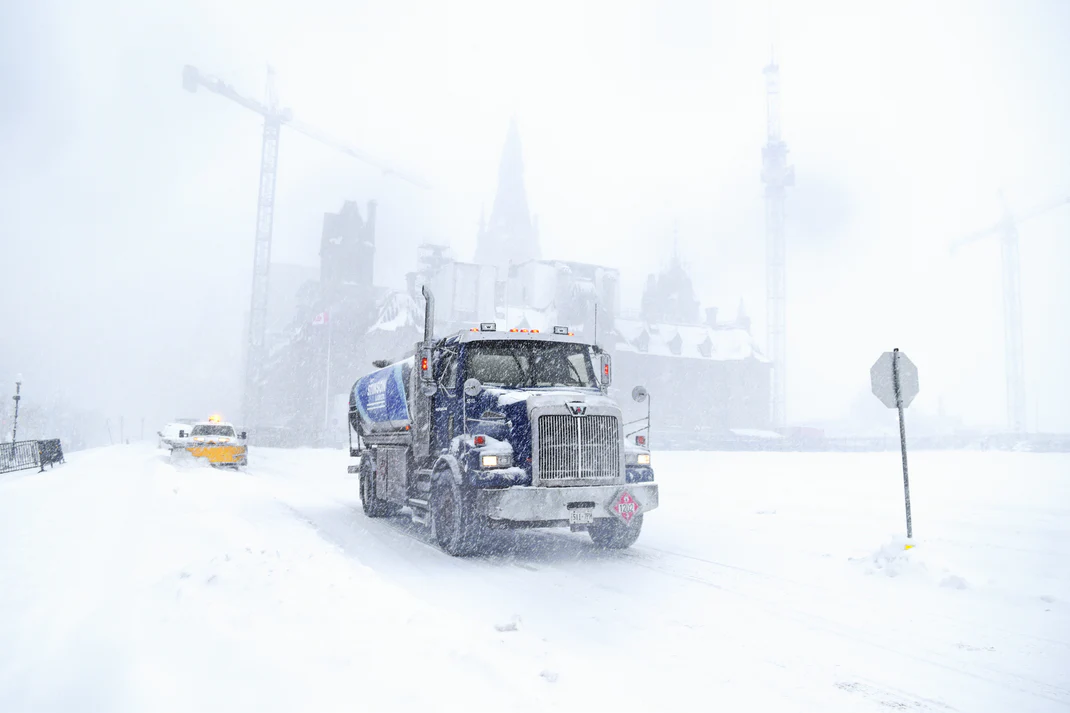 Snow removal trucks clearing roads during blizzard conditions